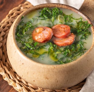 A Portuguese soup with potatoes, kale, and chorizo, topped with olive oil