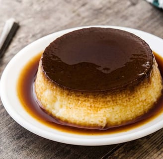 chocolate egg pudding with a silky texture, topped with a drizzle of chocolate sauce, in a white bowl