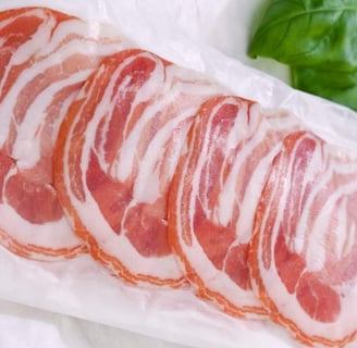 Pancetta slices packed in a lamination bag along with some leafs