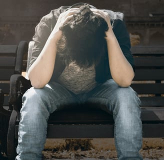 guy sitting on a park bench seemingly scared