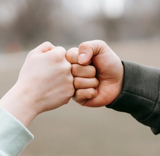 two trusting friends fist-bumping