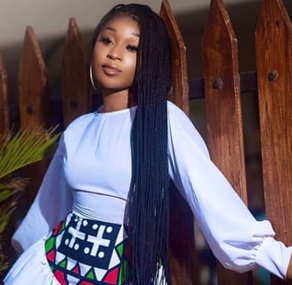 Efia Odo posed in a white top and material skirt.