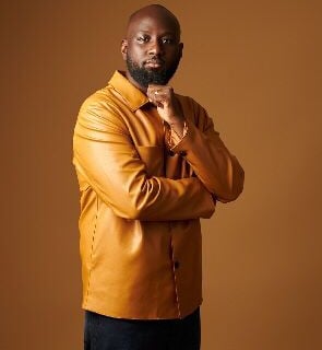 Kofi Karikari in a brown leather shirt.