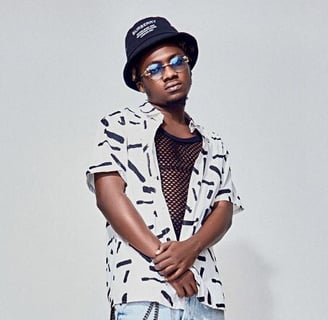 Kwesi Amewuga in a white shirt, in black shades and in a black hat.
