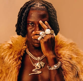 Stonebwoy with animal fur around his neck.