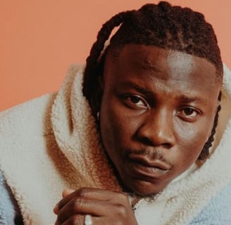 Stonebwoy in a brown sweater.