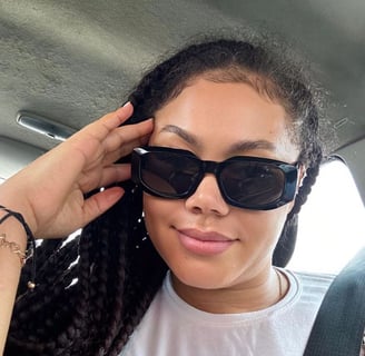 Nadia Buari in a white shirt with black sunglasses on.