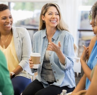 a group of people sitting around a table with coffee cups