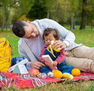 a man and a little girl sitting on a blanket