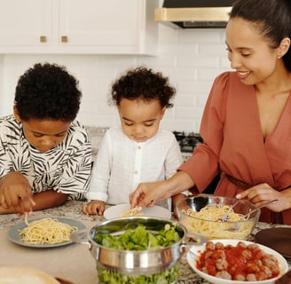 a woman and two children are cooking together