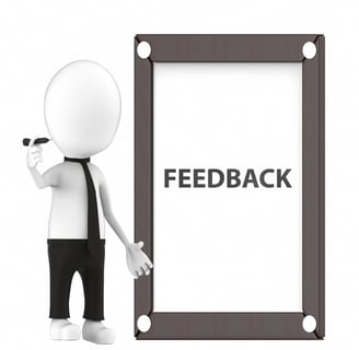 a person standing next to a sign that says feedback