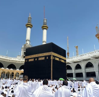 Vur de la kaaba au centre de la mosquée Al Haram à la Mecque, entourée de pèlerins en tenu d'ihram.
