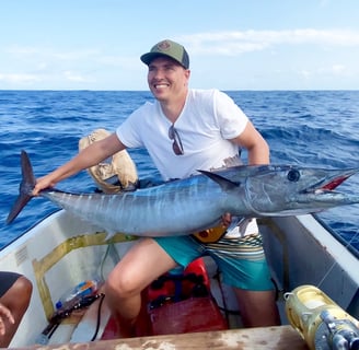 Happy angler holding a giant wahoo caught on a Half-Day Fishing Charter in Zanzibar