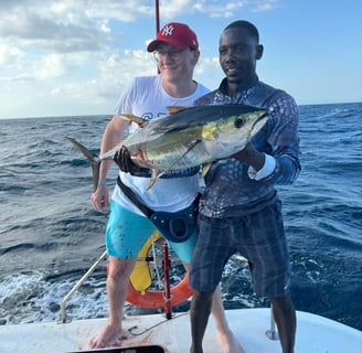 Angler showing off a caught Yellowfin Tuna on a catamaran - Catamaran Fishing Charters Seychelles