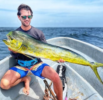 Fisherman showing off a vibrant dorado caught on a Half-Day Fishing Charter in Zanzibar