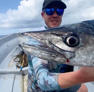 Deep sea fishing - a man holding a King Fish in a boat