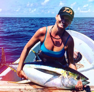 Woman proudly displaying a Yellowfin tuna during a Half-Day Fishing Charter in Zanzibar