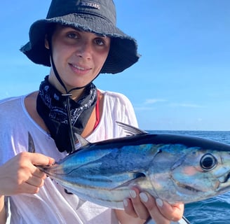 Girl proudly showing her caught fish on a catamaran - Catamaran Fishing Charters Seychelles