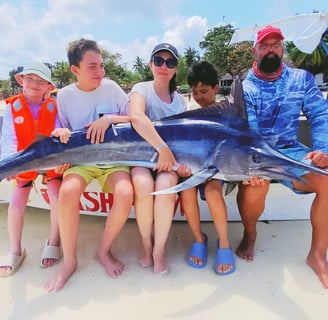 Family celebrating their catch of a black marlin on a Half-Day Fishing Charter in Zanzibar