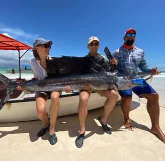 Excited anglers posing with a sailfish caught on a Half-Day Fishing Charter in Zanzibar