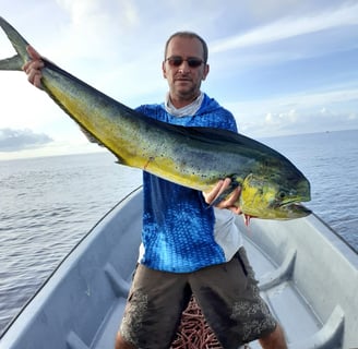 Excited fisherman with a freshly caught Dorado on a Full-Day Fishing Charter in Zanzibar