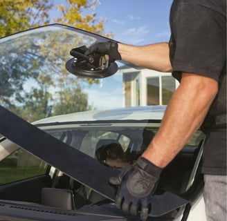 a man in a black shirt is holding a WINDSHIELD