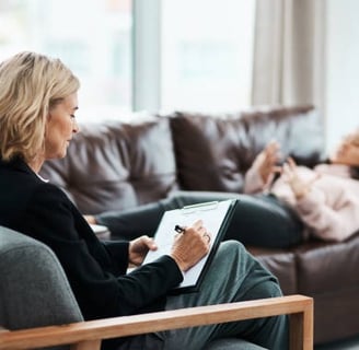 a woman sitting on a couch with a man in a chair