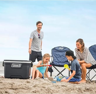 Una familia en la playa utilizando sus sillas Coleman