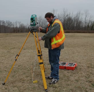 a man in a safety vest and a tripodod