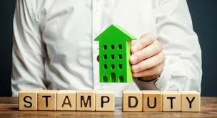 a man holding a green house with a green arrow pointing up to the word stamp