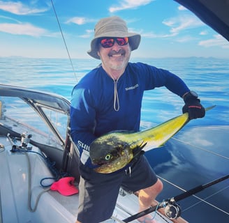 a man holding a fish on a boat