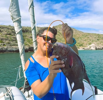 a woman holding a fish on a boat