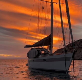 a sailboat in the water at sunset