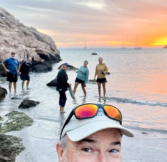 a man in a hat and hi friends on a beach