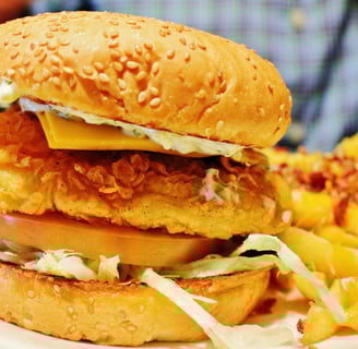 a burger - style chicken sandwich with cheese and fries