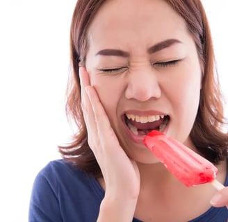 a woman with hands on cheek and mouth open with icecream on one hand