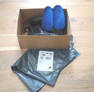 a box of shoes and a pair of custom insoles with returns envelope