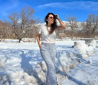 a woman in a white shirt and plaid pants