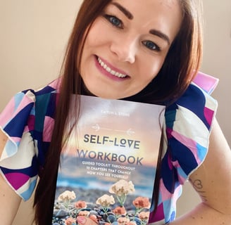 woman holding self love workbook