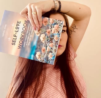 woman holding self love workbook