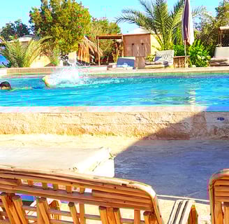 Băiat înot în piscină lângă mare și bungalou la starul beduin Egipt