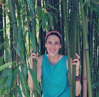 a woman standing in front of a bamboo tree