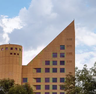 image of a tall brick building with a triangle shaped roof and a castle tower next to it
