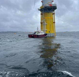 a boat in the water near a wind turbine
