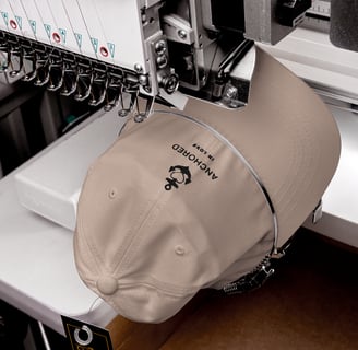 a beige cap being embroidered with anchor design