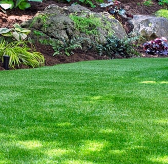 a lush green lawn with a stone wall and a stone wall