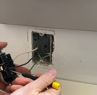 Using a tiny screwdriver to remove the wires from the receptacle without cutting them