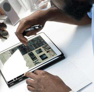 a man is holding a pen and writing on a tablet