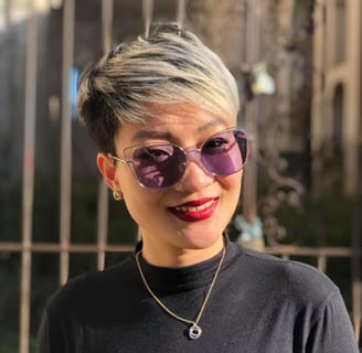 a woman with short hair and sunglasses on a fence