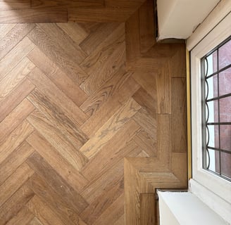 A brown oak herringbone floor with a double border